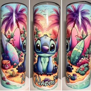 Op de afbeelding: Een roestvrijstalen beker met een kleurrijk tropisch ontwerp met Stitch, palmbomen en surfplanken. De achtergrond bevat een strandsc&egrave;ne met bloemen en de naam "Naomi". De beker is ongeveer 20 cm hoog.