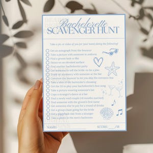 someone holding a printed 5x7in version of the bachelorette scavenger hunt game