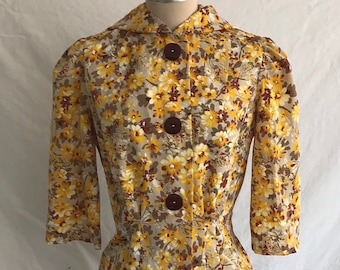 May include: A vintage floral print button-up jacket with a fitted waist. The jacket is beige with yellow and brown flowers.