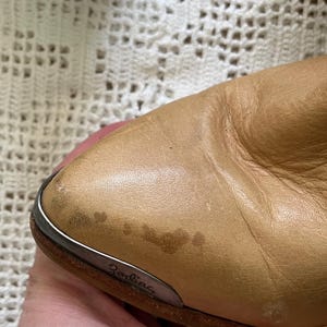 May include: Close-up of a tan leather boot with a silver metal trim and the word "Zodiac" embossed on the side.