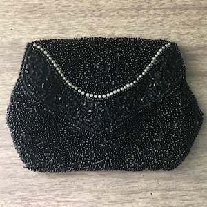 May include: A black beaded evening bag with a silver beaded trim.