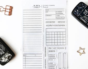 Op de afbeelding: Transparante stempels voor journalen en planning. De stempels bevatten een raster, een checklist, een gewoontetracker en een notitiegedeelte met de tekst "everyday is a new beginning".