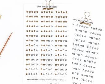 May include: Two sheets of star rating stickers. One sheet has gold stars, the other has black stars. The text "STAR RATING STICKERS" is printed at the top of each sheet. The bottom of the sheet has the text "MEDITERRANKA DESIGN | LIVEINCOLORPLANNER.COM".