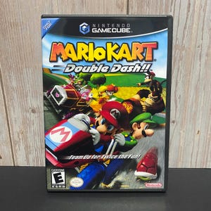 May include: A Nintendo GameCube game case for Mario Kart: Double Dash!! The cover art features Mario and Luigi in go-karts, with other characters and a race track in the background. The game is rated "E" for Everyone by the ESRB.