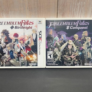 May include: Two Nintendo 3DS game cases. The games are "Fire Emblem Fates: Birthright" and "Fire Emblem Fates: Conquest". The Birthright case features a group of anime-style characters. The Conquest case features a different group of anime-style characters.