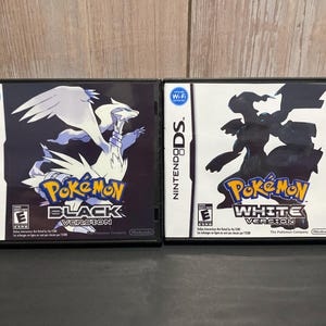 May include: Two Nintendo DS game cartridges, one black with a white Pokemon Black Version logo and the other white with a black Pokemon White Version logo.