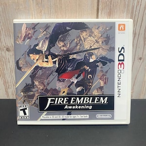 May include: A Nintendo 3DS game case for "Fire Emblem: Awakening." The cover art features multiple characters in action poses with swords and other weapons. The game is rated "T" for Teen by the ESRB.
