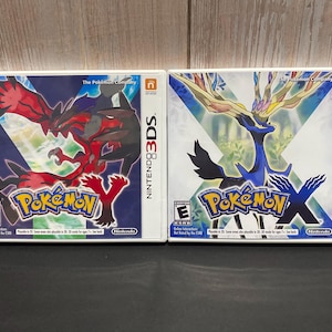 May include: Two Nintendo 3DS game cases, one for Pokemon X and one for Pokemon Y. The Pokemon X case features a blue and black Pokemon with a large, branching head. The Pokemon Y case features a red and black Pokemon with a large, branching head.