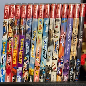 May include: A collection of Nintendo Switch game cases, featuring titles like "Pok&eacute;mon Sword," "Pok&eacute;mon Scarlet," and "The Legend of Zelda: Breath of the Wild." The cases have colorful artwork and the Nintendo Switch logo.