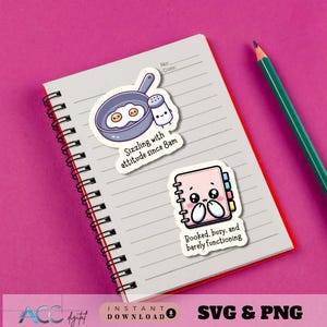 May include: A notebook with stickers featuring cute illustrations of a frying pan with eggs, a salt shaker, and a planner. The stickers have text that reads "Sizzling with attitude since 8am" and "Booked, busy, and barely functioning". A green pencil rests on the notebook.