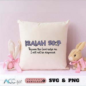May include: A white pillow with the text "ISAIAH 50:7 Because the lord helps me I will not be disgraced." printed in purple on it. The pillow is sitting on a pink surface with a stuffed bunny rabbit on the right side of the pillow.