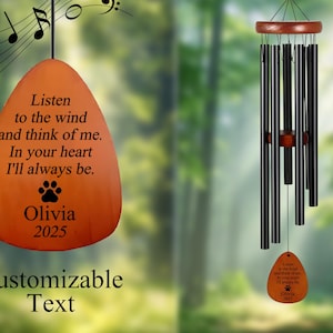 May include: Orange wind chime with black chimes and a wooden top. The chime features the text "Listen to the wind and think of me. In your heart I'll always be." with a paw print and the name "Olivia 2025".