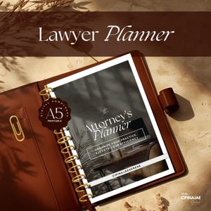 May include: A brown leather A5 Lawyer Planner with gold accents. The planner features a printed cover with the text "The Attorney's Planner" and "Organize your practice, elevate your efficiency". A gold paperclip is visible.