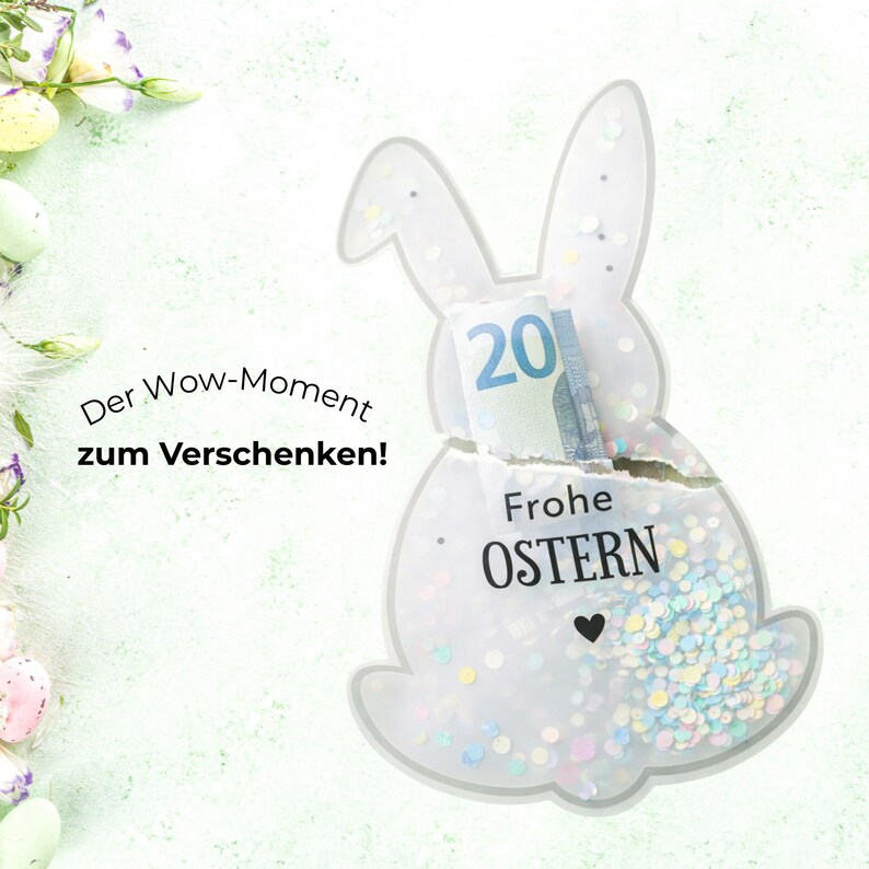 May include: A clear, bunny-shaped gift holder filled with confetti and a twenty-dollar bill. The words "Frohe OSTERN" are printed on the front. The text "Der Wow-Moment zum Verschenken!" is on the left.