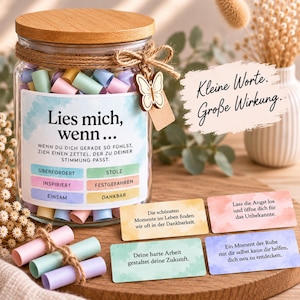 May include: A clear glass jar with a wooden lid, filled with colorful rolled paper notes. The label reads "Lies mich, wenn..." with categories like "Überfordert" and "Stolz." A wooden butterfly charm hangs from the twine tied around the neck.