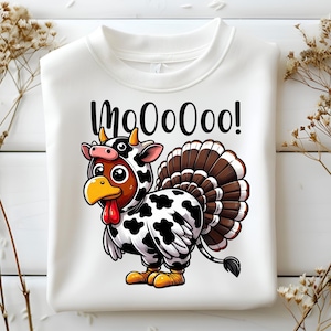 May include: White sweatshirt featuring a cartoon turkey wearing a cow costume. The turkey has a yellow beak, red wattle, and a brown and white tail. The text "MooOooo!" is above the turkey.
