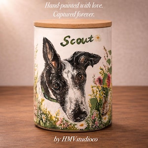 May include: A cylindrical ceramic canister with a light wood lid, featuring a hand-painted portrait of a black and white dog named Scout surrounded by colorful wildflowers. The text reads: Hand-painted with love. Captured forever. by HMVstudioco.