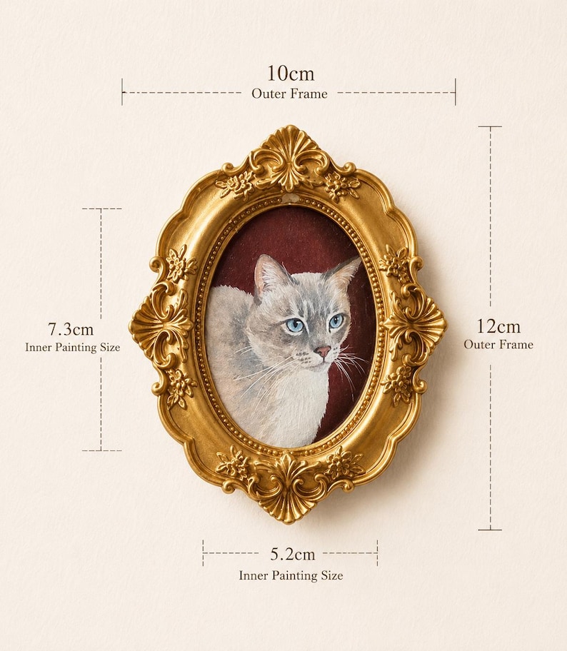 May include: An oval gold-colored frame with ornate floral detailing containing a painting of a light-colored cat with blue eyes against a dark red background. The frame measures 10 cm by 12 cm, with an inner painting area of 5.2 cm by 7.3 cm.