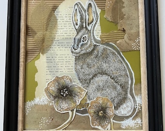 Conejito y flores en técnica mixta con collage que incluye papel vintage. Una segunda capa de vidrio encolado le da profundidad.