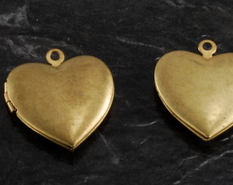 May include: Two gold-tone heart-shaped locket pendants with a hinged opening. The lockets have a smooth, polished finish.