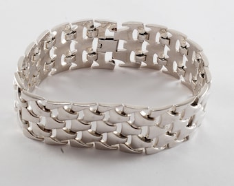 May include: A silver bracelet with a unique interlocking chain design.