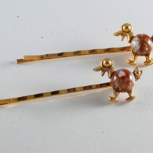 Grampos de cabelo vintage em metal dourado com formato de pato e cabochão de gemaxita.