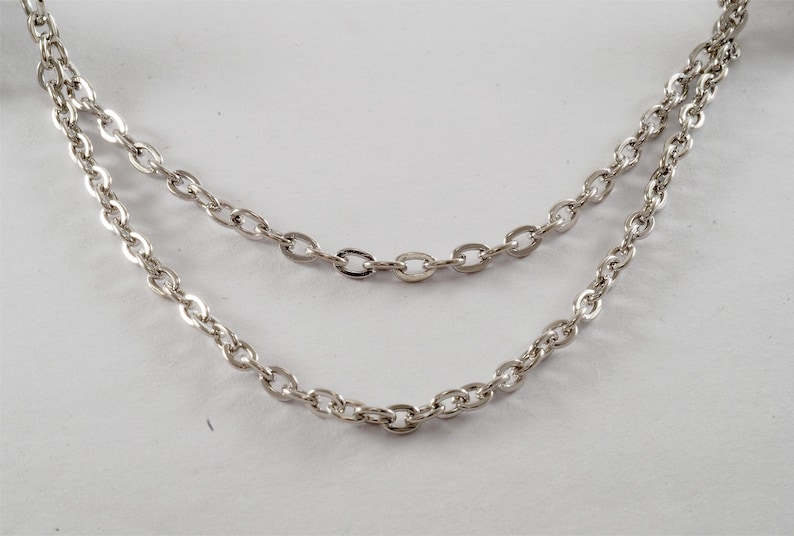 Puede incluir: Un collar de cadena de plata con dos hebras de eslabones ovalados.