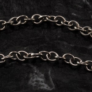 May include: A silver chain necklace with a simple, linked design. The chain is made of metal and has a polished finish.