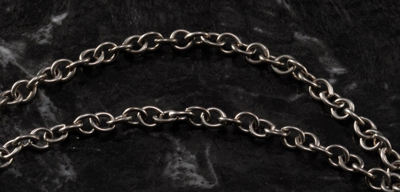 May include: A silver chain necklace with a simple, linked design. The chain is made of metal and has a polished finish.