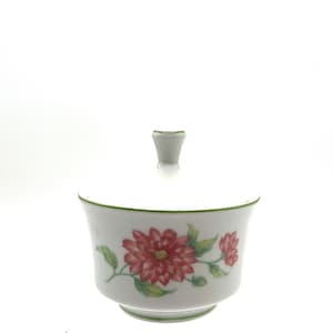 May include: White porcelain sugar bowl with a lid, featuring a floral design with red flowers and green leaves.