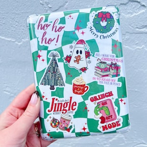 Op de afbeelding: Een transparante telefoonhoes met een groen-wit geruite achtergrond. De hoes is versierd met verschillende kerst-stickers, waaronder een geest, een kerstboom, een krans, een koffiebeker en een Grinch-sticker met de tekst "Grinch On Off Mode".