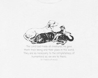May include: White t-shirt featuring a black and white illustration of a dog and two cats. The dog is lying down, with a tabby cat and a kitten resting on top. Text below reads, "The Lord God made all creatures...St. Francis of Assisi."