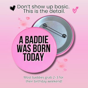 May include: A pink button with the text "A BADDIE WAS BORN TODAY" in black. The button is set against a pink background with the text "Don't show up basic. This is the detail." and "Most baddies grab 2-3 for their birthday weekend!"