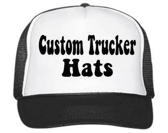 May include: A white trucker hat with a black mesh back. The front of the hat has the text "Custom Trucker Hats" in black.