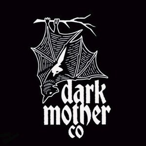 Puede incluir: Gr&aacute;fico en blanco y negro de un murci&eacute;lago colgado boca abajo de una rama. El murci&eacute;lago tiene patrones de alas detallados y est&aacute; posicionado encima de las palabras "dark mother co" en una fuente estilizada. El dise&ntilde;o est&aacute; sobre un fondo negro.