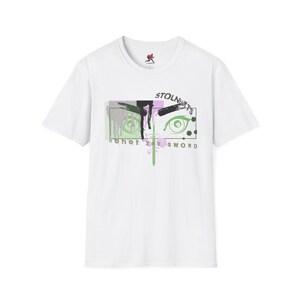 May include: White t-shirt with a graphic design. The design features the text "STOLNIGHTS" above a pair of stylized eyes. The artwork includes a sword and the words "Honor thy sword". The design incorporates green, black, and purple accents.