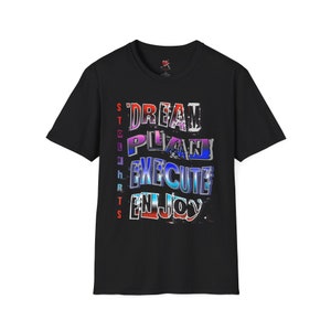 Könnte beinhalten: Schwarzes T-Shirt mit den Worten "DREAM, PLAN, EXECUTE, ENJOY" in einer bunten, verwitterten Schriftart. Das Wort "STRENGTHS" ist vertikal auf der linken Seite aufgedruckt. Ein klassisches Rundhals-T-Shirt.