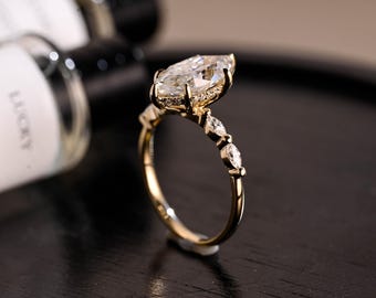 Förlovningsring med moissanit i massivt guld med sidosten och marquise-slipad moissanit, vigselring med moissanit i dold gloria