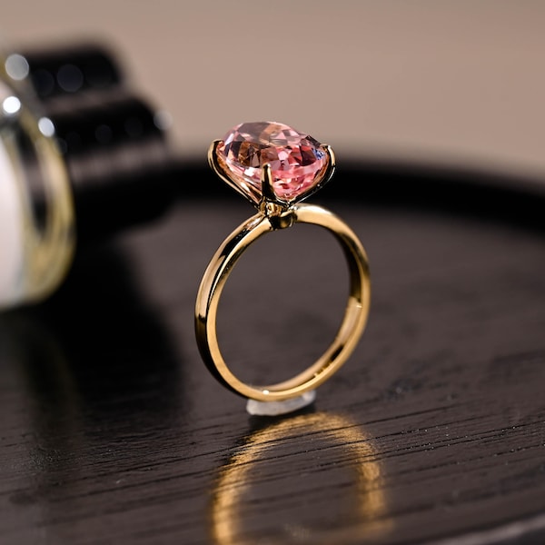 Anillo de compromiso de oro macizo con engaste tipo tulipán y zafiro rosa ovalado cultivado en laboratorio.