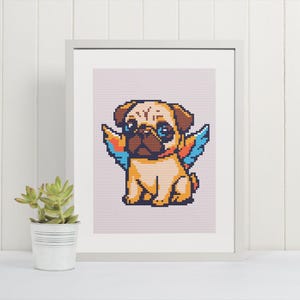 May include: Framed pixel art print of a pug dog with colorful wings. The pug is tan with a dark brown muzzle and blue eyes. The wings are blue, orange, and yellow. The print is in a white frame and sits on a white surface.