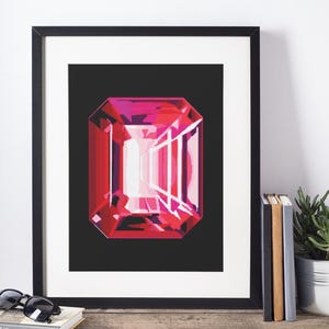 Puede incluir: Impresión artística enmarcada que presenta una gran gema roja estilizada con corte rectangular. La gema tiene un degradado de tonos rosas y rojos, sobre un fondo negro. La impresión está en un marco negro.