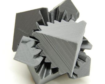 May include: A gray 3D printed geometric shape with interlocking gears. The shape is made up of multiple triangular and rectangular pieces.