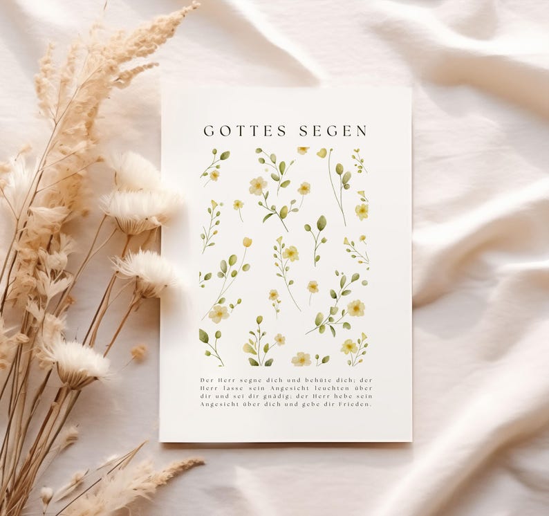 May include: A white card with the text "GOTTES SEGEN" and a floral design. The card features watercolor illustrations of yellow flowers and green leaves. The bottom of the card has a paragraph of text in German.