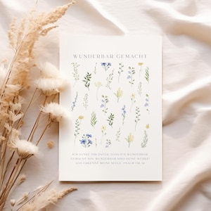 May include: A white card with the text "WUNDERBAR GEMACHT" and a floral design. The card features watercolor illustrations of various flowers in shades of green, yellow, and blue. The bottom of the card has additional text in German.