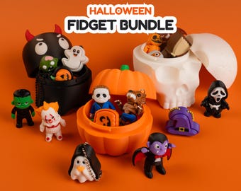 Peut inclure: Un ensemble de fidgets d'Halloween comprenant un récipient diable noir, un récipient citrouille orange et un récipient crâne blanc remplis de petites figurines sur le thème de l'horreur, dont un fantôme, un vampire et d'autres icônes effrayantes.