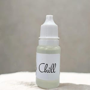 May include: A small clear glass bottle with a white cap and a white label that says "Chill".
