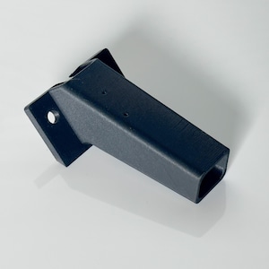May include: A black plastic 3D printed bracket with a rectangular opening. The bracket has a flat base with a round hole and a long, rectangular arm.