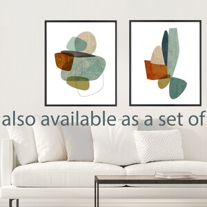 May include: Two abstract art prints with geometric shapes in shades of blue, green, brown, and beige. The prints are framed in black and are displayed on a white wall above a white couch.