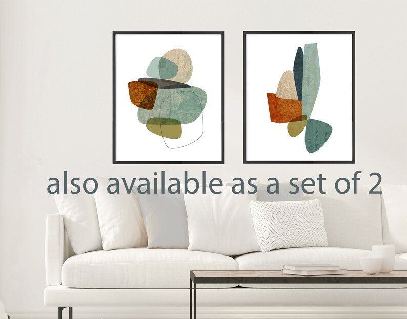 May include: Two abstract art prints with geometric shapes in shades of blue, green, brown, and beige. The prints are framed in black and are displayed on a white wall above a white couch.