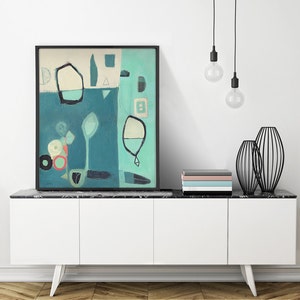 May include: Abstract painting in shades of blue, green, and white with geometric shapes and lines. The painting is framed in black and displayed on a white cabinet with a black marble top.